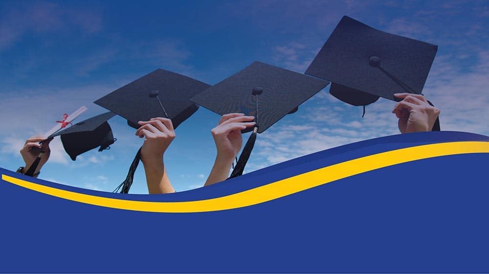Image of graduates holding their cap