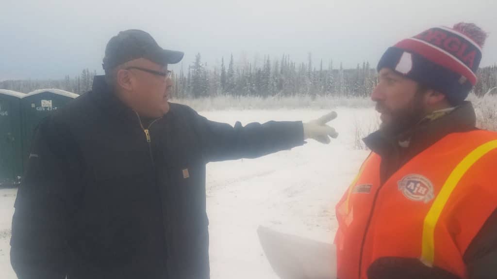 Ahtna shareholder Jerry Charley Jr. coordinates logistics with a race volunteer at the Sourdough Checkpoint.