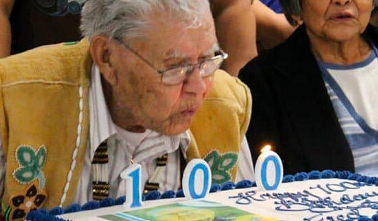 Chief Fred blowing cake candles on his 100th Birthday