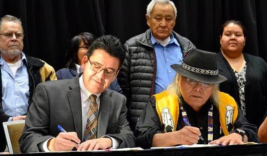 Ahtna shareholders sitting at conference table signing document