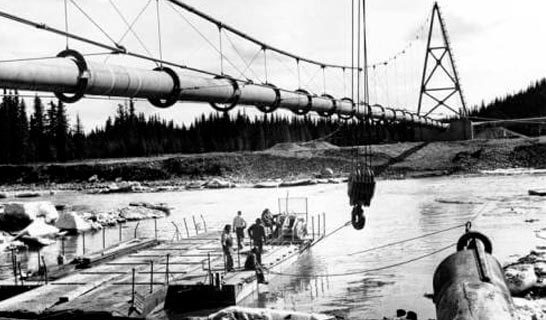 Black and white photo of Tazlina River and pipeline suspension bridge