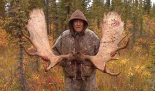 Photo of Roy Ewan holding moose antlers