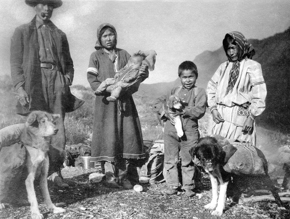 Old black and white photo of family with kids and dogs