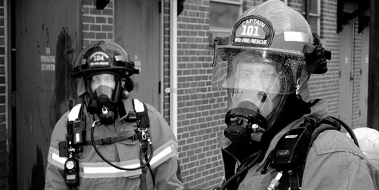 Black and white photo of firemen in full gear