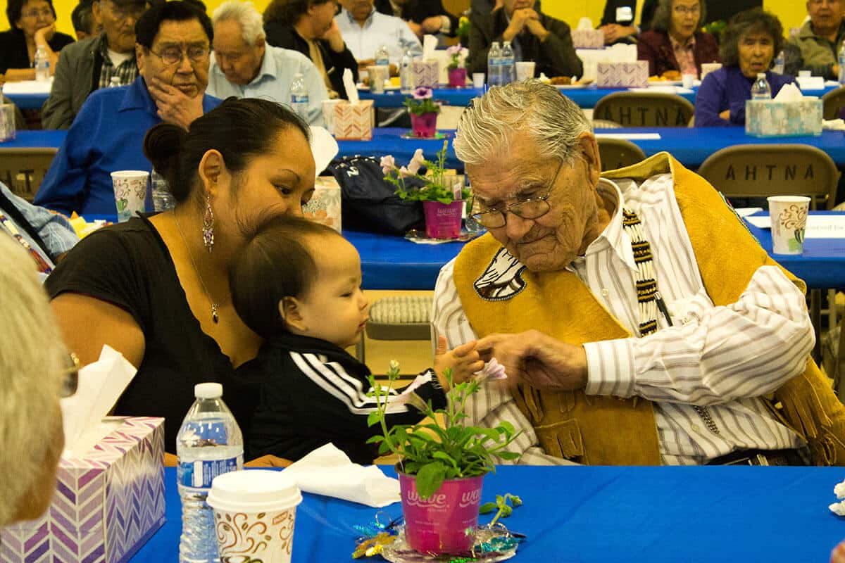 Rachel Ewan and her son visit with Chief Fred Ewan during the 2016 Annual Meeting.