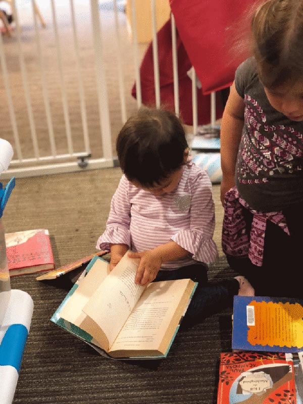 Children at the CRNA Child Development Center look through the donated books.