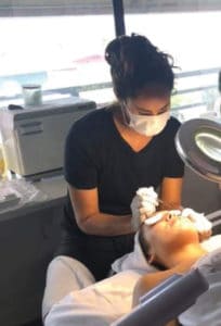 Erika Empey working as an esthetician with a client