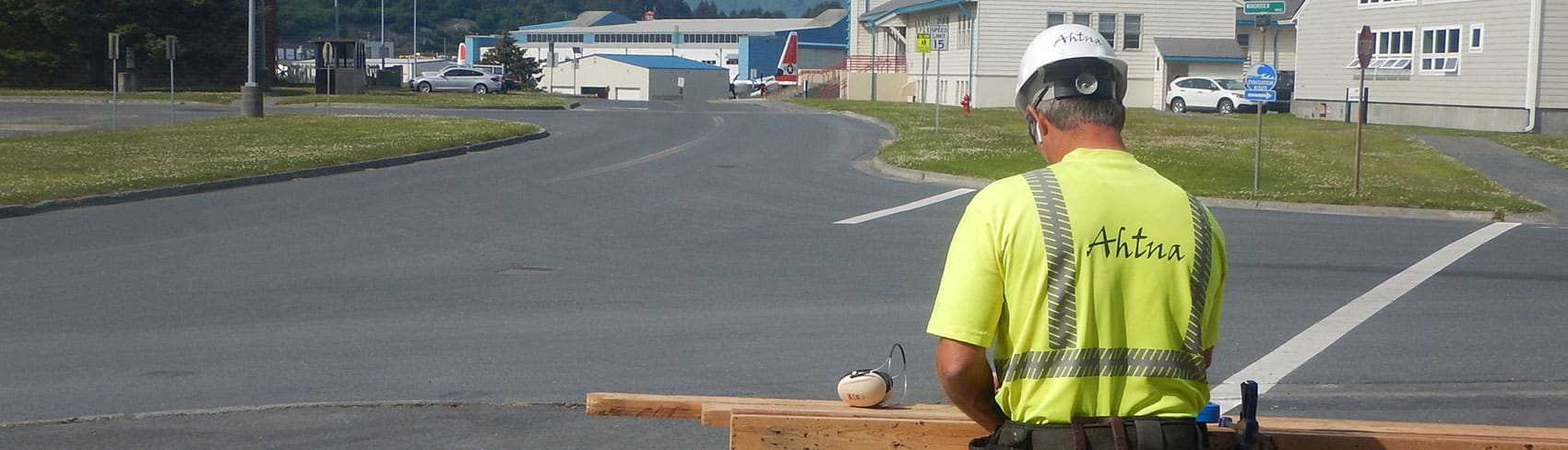 Ahtna construction worker cuts boards outside job site.