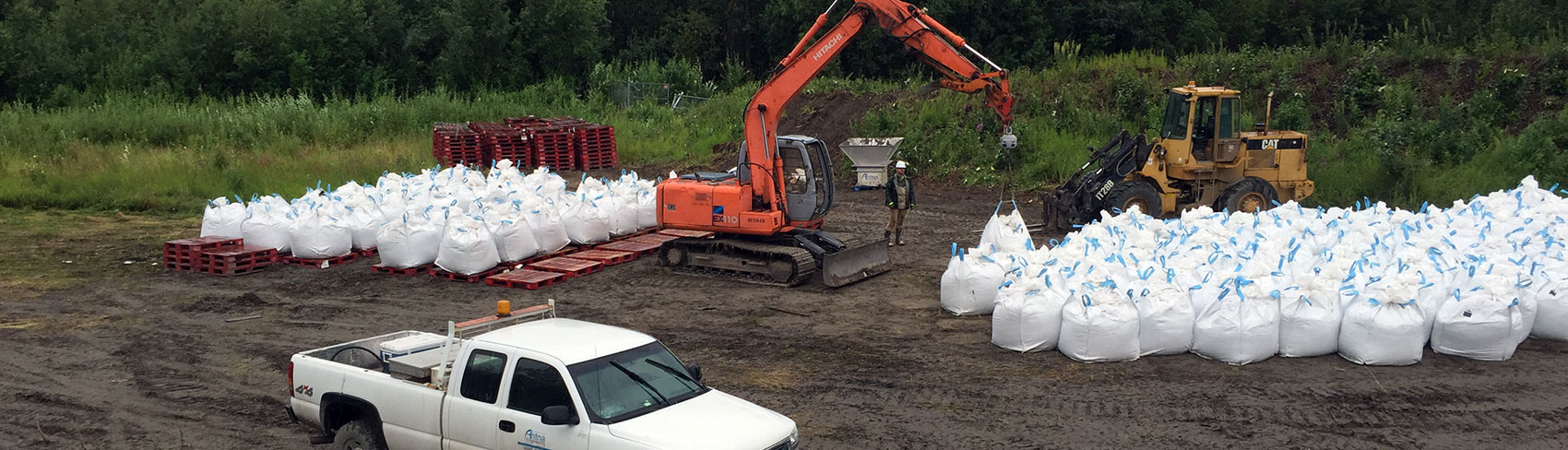 Excavator loads up bags of waste.