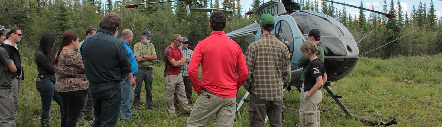 Land team gathers around a helicopter.