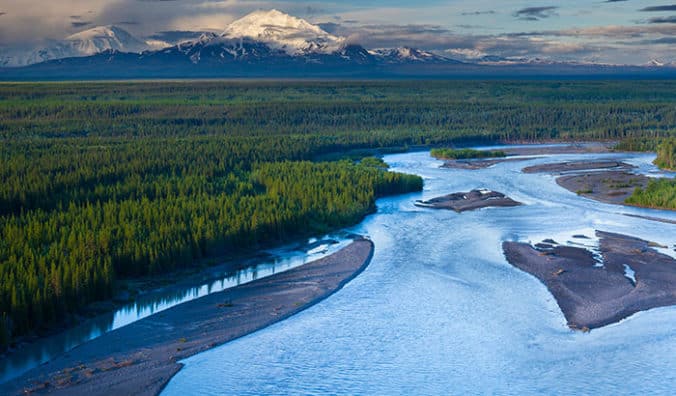 View of Alaskan river with mountain in the background.