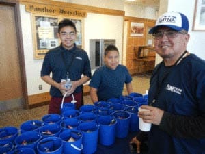 Markus Johns and Harry Ewan with Dad, Mark Johns assisting with handing out the Berry Buckets