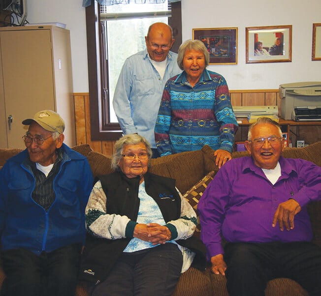 Sister Jane Nicholas and her husband Gregory sit on the couch with Roy while Roy’s other sister, Helga Wiebe and husband Ray, pose behind them.