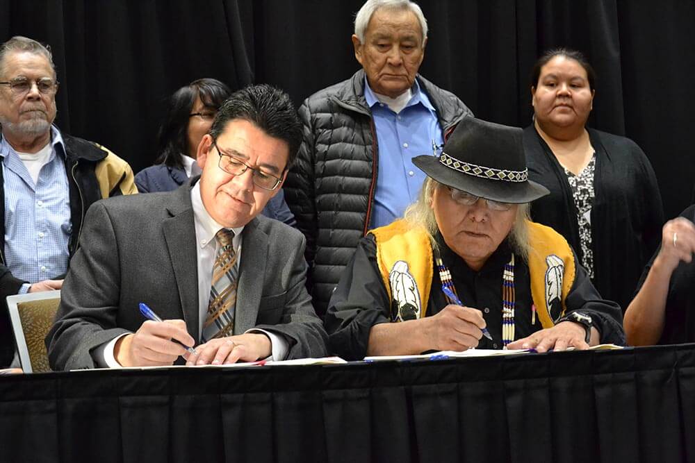 Ahtna shareholders sitting at table signing document