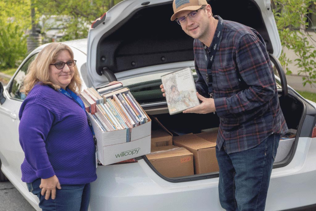 Denise Yancey, AEI and Rodney Lengele, AES/AI Intern load books for delivery.